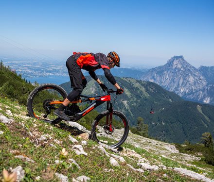 Eine Person fährt mit einem Mountainbike bergab in den Alpen.