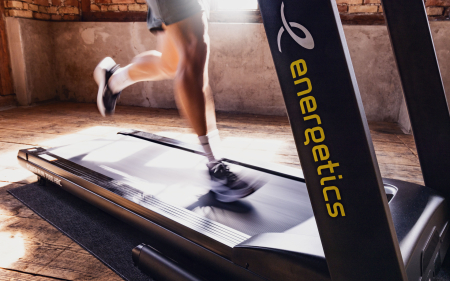 Mann läuft auf einem Energetics-Laufband drinnen für ein Fitness-Workout, Cardio-Training und Übungen.