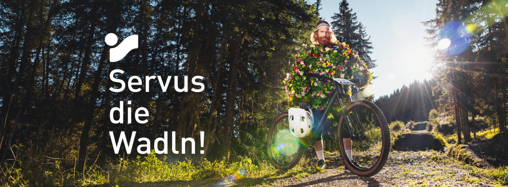 Mann im Blumenoutfit, der im Freien auf Fahrrad sitzt, Naturfotografie.