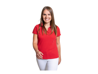 Lächelnde Frau in rotem Poloshirt und weißer Hose geht auf weißem Hintergrund. Professionelles Porträt.