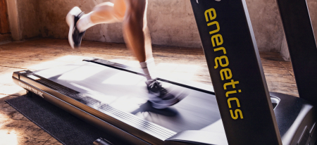 Eine Person, die auf einem Laufband der Marke Energetics für Indoor-Cardio-Training und Fitnesstraining läuft.