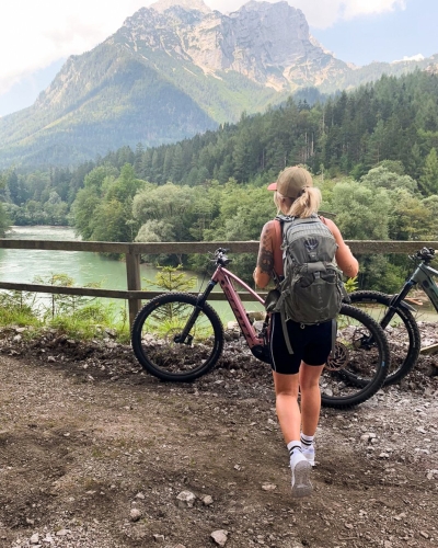 Frau fährt Mountainbike mit Rucksack in den Dolomiten, Italien, malerische Berglandschaft.