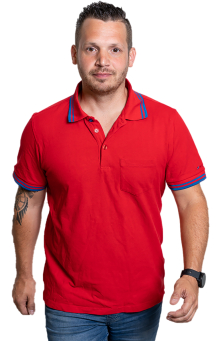 Mann im roten Poloshirt und Jeans. Porträt eines selbstbewussten männlichen Models mit Tattoo und Uhr.