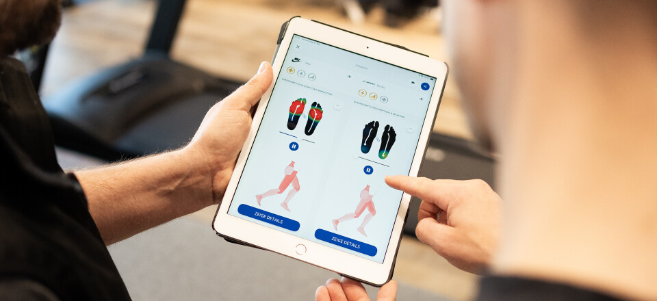 Fußscan auf einem Tablet, der Druckpunkte für die Anpassung von individuellen orthopädischen Einlagen in einem Schuhgeschäft zeigt.