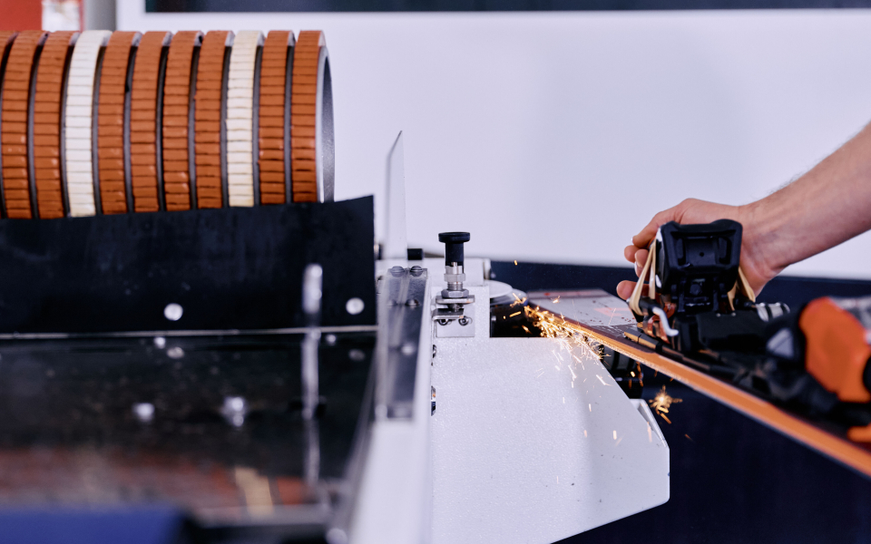 Skischleifmaschine schärft Skikanten, wobei Funken in einer Skiwerkstatt sprühen.