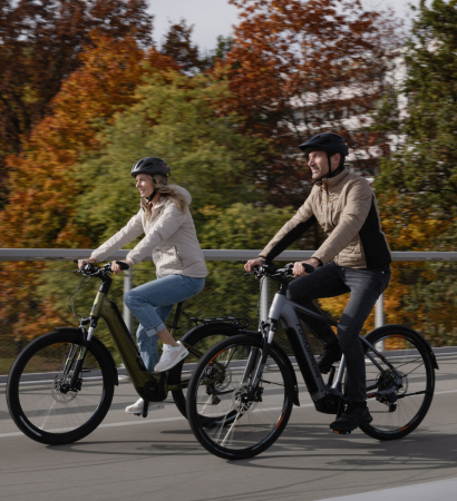 Fahrradladen: Ein Mechaniker repariert ein Fahrradrad, während Kunden Reifen und Zubehör durchstöbern.