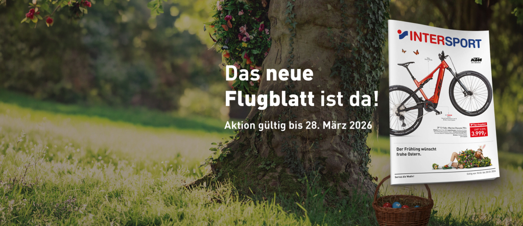 Intersport-Flyer mit einem roten Mountainbike, platziert in einer Frühlingswiese mit Baum und Osterkorb.